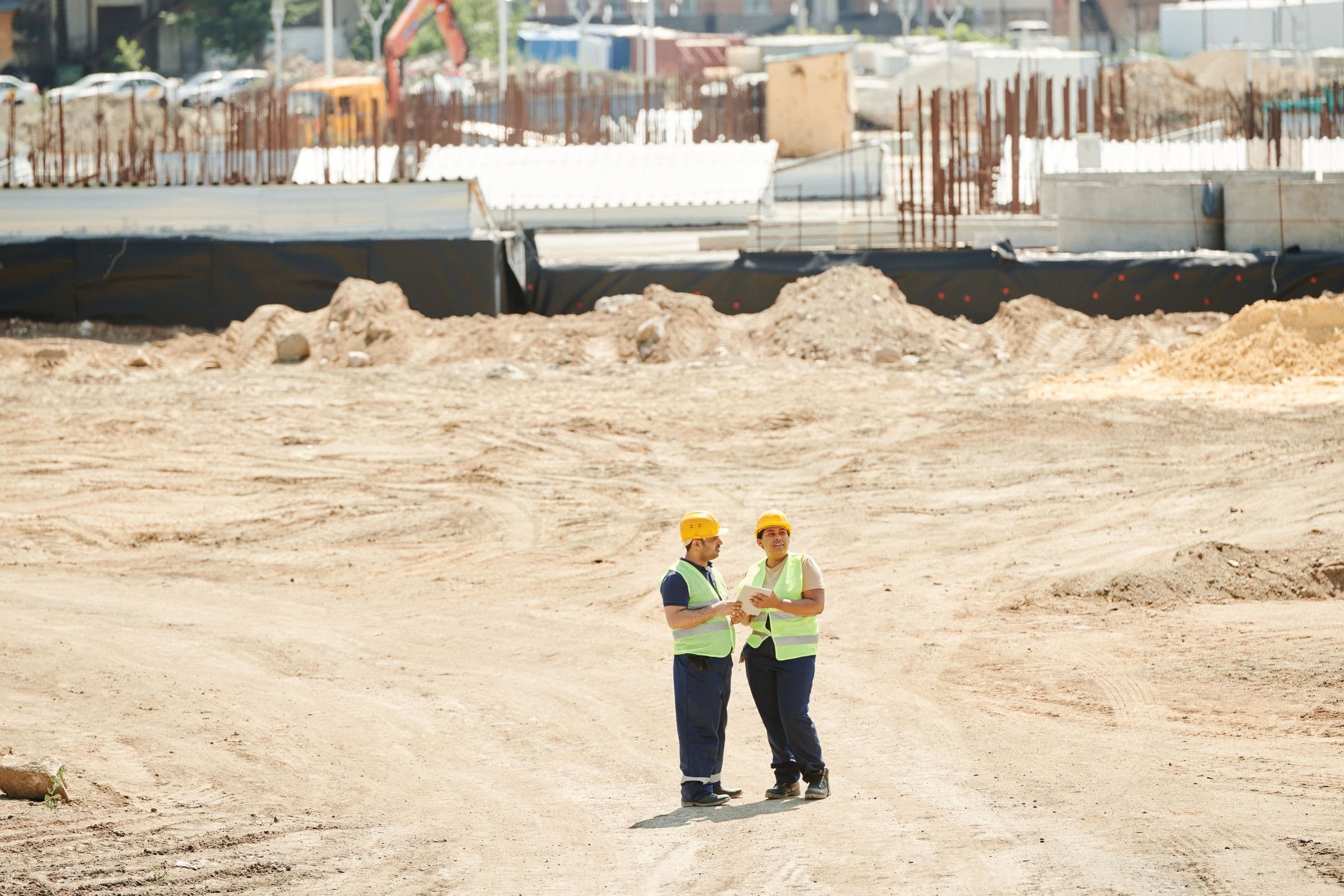 Two construction workers reviewing plans on site